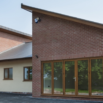 Closed woodgrain PVCu doorsin a brick house